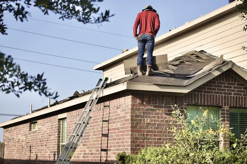 Professional roofer working on a residential roof in Via Marina
